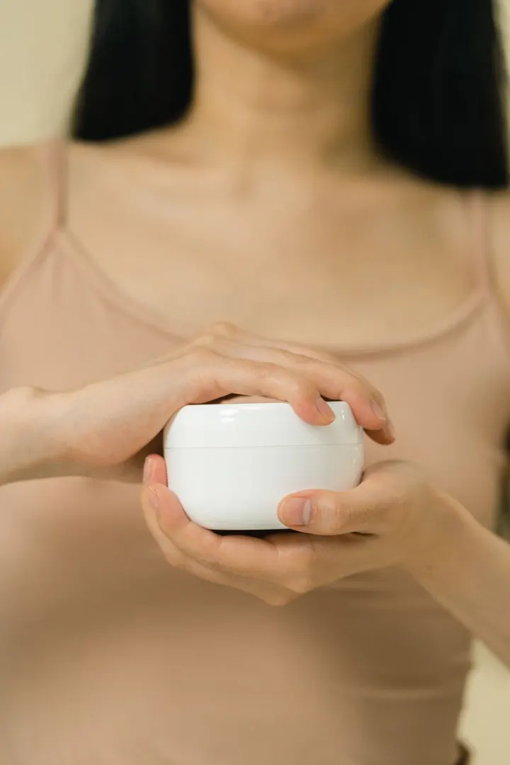 Pote de creme hidratante nas mãos