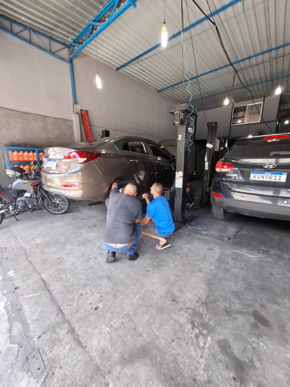 Mecânicos do Léo Auto Center trabalhando no elevador