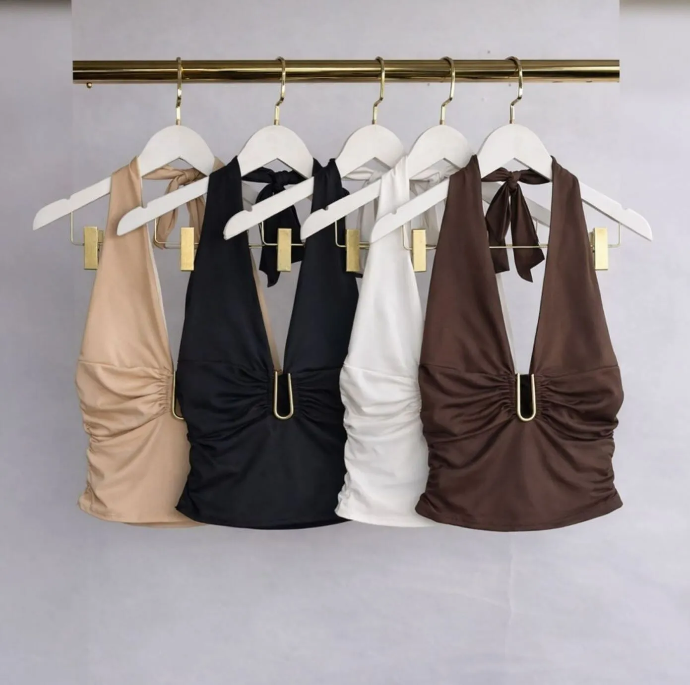 Arara com blusas de diversas cores com decote elegante em destaque